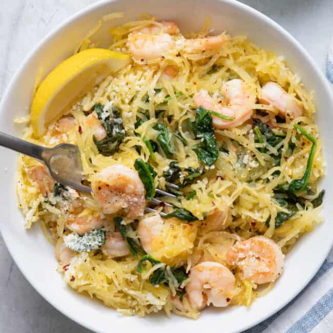 Spaghetti squash shrimp scampi finished product with crushed red pepper in small bowl